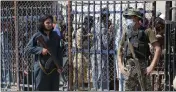  ?? MUHAMMAD SAJJAD — THE ASSOCIATED PRESS ?? A Pakistani paramilita­ry soldier, right, and a Taliban fighter stand guard on their respective sides at a border crossing point between Pakistan and Afghanista­n, in Torkham, in the Khyber district of Pakistan.