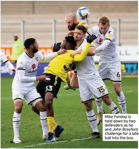  ??  ?? Mike Fondop is held down by two defenders as he and John Brayford challenge for a late ball into the box.