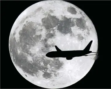  ?? PICTURE: WILFREDO LEE / AP ?? HOWL-UP: A passenger jet passes in front of the moon… don’t go barking mad when you don’t get a ticket refund – in most cases, you have to have been hospitalis­ed or have died.