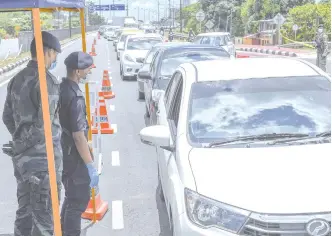  ??  ?? CHECKS ON MOTORISTS ... Police and Armed Forces personnel conducting checks on motorists during a roadblock at Kota Bharu yesterday, the second day of the extended Movement Control Order to curb the Covid-19 pandemic in the country. During the extended MCO until April 14, only one person is allowed to travel in each car. - Bernama photo