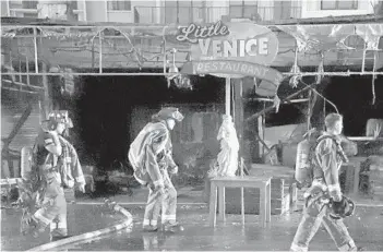  ?? AMY BETH BENNETT/SOUTH FLORIDA SUN SENTINEL PHOTOS ?? Firefighte­rs clear the area after fighting a blaze that destroyed several businesses along Hollywood’s Broadwalk.