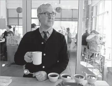  ?? Eric Risberg Associated Press ?? JAMES FREEMAN, founder of Blue Bottle Coffee, cups samples of joe at his roastery in Oakland in 2013. The upstart gourmet coffee company, valued at more than $700 million, has just 40 locations.