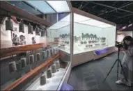  ?? HOU YU / CHINA NEWS SERVICE AND ZHU WEI / XINHUA ?? Bronze bells and ritual vessels (above) and holding vessels (below) on display.
