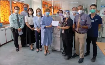  ?? — Photos by Peter Boon ?? Annie (fifth left) hands over the haemodialy­sis machines to nephrologi­st Dr Lau Siew Ping, as Dr Nanthakuma­r (front, right) and others look on.