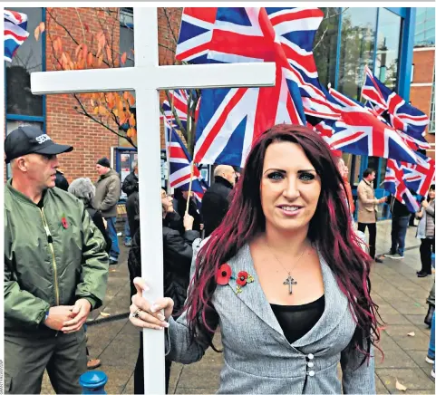  ??  ?? Jayda Fransen, the deputy leader of Britain First, brandishes a cross at a rally outside Bromley police station, south-east London, earlier this month
