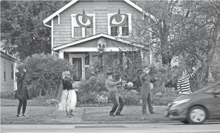  ?? PHOTOS BY ADAM CAIRNS/COLUMBUS DISPATCH ?? From left, Shirley Tobias, Sarah Reinhart, Doug Yost, Dan Doremus and Bob Barnes spread some Halloween spirit in Clintonvil­le.