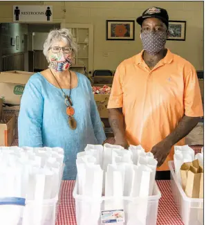  ?? (Arkansas Democrat-Gazette/Cary Jenkins) ?? As board chairwoman for the Stewpot, Nancy Howell has steered the change — necessitat­ed by the covid-19 pandemic — in getting midday meals to the hungry in downtown Little Rock. Instead of diners coming in to eat, they receive sack lunches distribute­d by employee Ed Brown (right). Howell says Stewpot ensures that meals are not just nutritious, but fun. “We’re not going to make them ‘eat their turnips,’” she says.