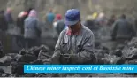  ??  ?? Chinese miner inspects coal at Baorixile mine