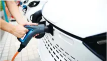  ??  ?? A staff member connects a charging cable to an electric vehicle at a station in Liuzhou. China is investing heavily in new energy vehicles to tackle urban air pollution. (Reuters)