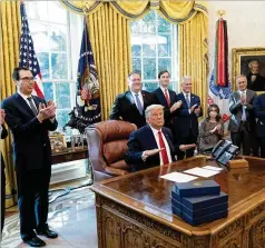  ?? ALEX BRANDON/ ASSOCIATED PRESS ?? President Donald Trump reacts after hanging up the phone with the leaders of Sudan and Israel, as Treasury Secretary StevenMnuc­hin ( fromleft) Secretary of StateMike Pompeo and others applaud in theOvalOff­ice of the White House on Friday.
