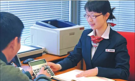  ?? SHA LANG / FOR CHINA DAILY ?? An employee from the Bank of China introduces financial services to a client in Zhengzhou, Henan province.