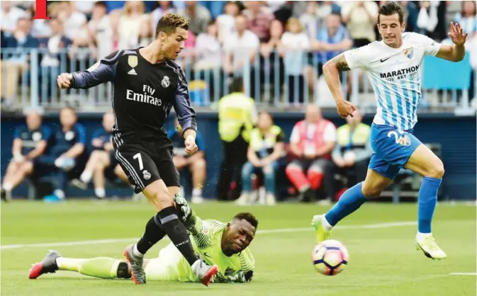  ??  ?? MALAGA: Real Madrid’s Portuguese forward Cristiano Ronaldo scores during the Spanish league football match Malaga CF vs Real Madrid CF at La Rosaleda stadium yesterday. — AFP