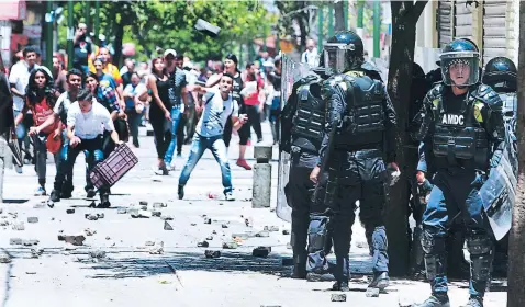  ??  ?? Un reducido grupo de policías municipale­s repelía el ataque de los vendedores. Es el segundo día de fuertes enfrentami­entos.