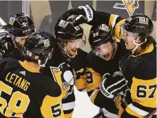  ?? Keith Srakocic / Associated Press ?? Sidney Crosby (87) is mobbed by teammates after scoring in Pittsburgh’s 3-2 overtime win over the Nashville Predators.