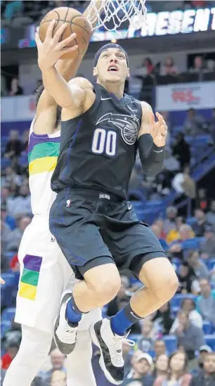  ?? TYLER KAUFMAN/AP ?? Magic forward Aaron Gordon goes up for a shot Tuesday night as Pelicans center Jahlil Okafor defends.