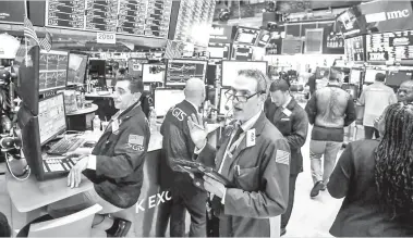  ??  ?? SAHAM: Pekerja bekerja di tingkat Bursa Saham New York (NYSE) di New York, AS, Disember 28. — Gambar Reuters