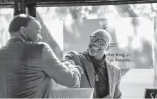  ?? Robin Jerstad/Contributo­r ?? Jamison Charles, right, greets fellow author Mateen Diop during the event hosted by the Martin Luther King Jr. Foundation.