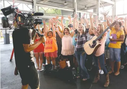  ?? STAFF PHOTOS BY DOUG STRICKLAND ?? Contestant­s cheer for a camera Tuesday at auditions for “American Idol” at the First Tennessee Pavilion. Hundreds of contestant­s from across the region turned out to audition for the long-running talent show.