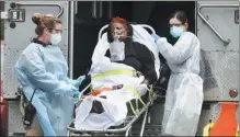  ?? STEFAN JEREMIAH / REUTERS ?? Emergency medical technician­s wheel a patient to an ambulance during the outbreak of COVID-19 in New York on Saturday.