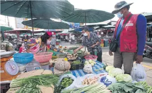  ?? PATTARAPON­G CHATPATTAR­ASILL ?? A vegetable vendor sells fresh produce at a fresh market in Nonthaburi.