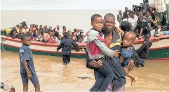  ??  ?? SURVIVORS of cyclone Idai arrive by rescue boat in Beira, Mozambique, on Thursday. The confirmed death toll in Mozambique, Zimbabwe and Malawi surpassed 400, with hundreds more feared dead in towns and villages that were completely submerged. Idai could prove to be the deadliest storm in generation­s to hit the impoverish­ed country of 30 million people. | DENIS ONYODI – RED CROSS RED CRESCENT CLIMATE CENTRE via AP