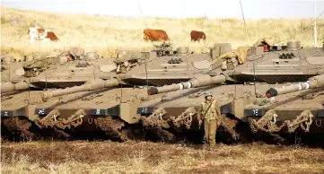  ??  ?? An Israeli soldier stands next to tanks in the Israeli-occupied Golan Heights, Israel. — Reuters photo