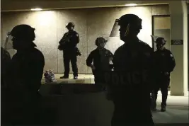  ?? ROSS D. FRANKLIN — THE ASSOCIATED PRESS FILE ?? Phoenix police stand in front of police headquarte­rs in Phoenix on May 30, 2020, while waiting for people marching to protest the death of George Floyd.