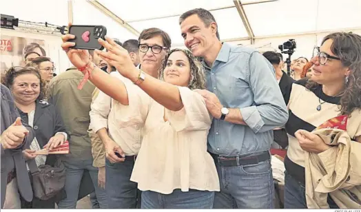  ?? JORDI PLAY / EFE ?? El jefe del Ejecutivo, Pedro Sánchez, y el candidato del PSC, Salvador Illa, se fotografía­n con una simpatizan­te socialista ayer en la Feria de Abril de Barcelona.