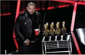  ?? (AP/Chris Pizzello) ?? Post Malone appears on stage Wednesday with his nine awards, including top male artist and top artist, at the Billboard Music Awards at Los Angeles’ Dolby Theatre.