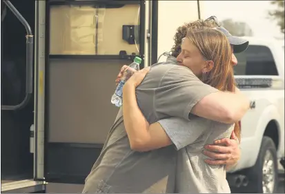  ?? PHOTOS BY CARIN DORGHALLI — ENTERPRISE-RECORD ?? Katherine Molohon hugs James “Woody” Faircloth to thank him for setting her up with a recreation­al vehicle on Saturday in Oroville. Molohon is a volunteer firefighte­r in Berry Creek. She lost her home in the North Complex fire.