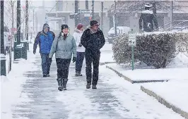  ?? Sarah A. Miller /Idaho Statesman via AP ?? ■ Kelly Hall and her brother Geof Finley take a walk in the snow Wednesday in downtown Boise, Idaho. The National Weather Service is forecastin­g very cold temperatur­es in the Treasure Valley from Friday night through Sunday. Snow will continue today.