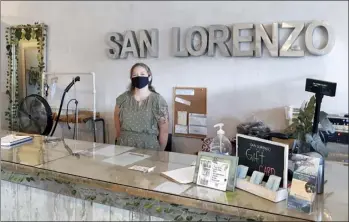  ?? The Maui News / DAKOTA GROSSMAN photos ?? Manager Breanna Racoma smiles through her face mask Monday at San Lorenzo Bikinis Maui, a swimsuit and clothing store that has remained open for most of the pandemic.