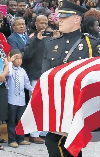  ?? STEPHEN M. DOWELL/STAFF PHOTOGRAPH­ER ?? A small boy salutes as the casket of slain Orlando Police Lt. Debra Clayton is carried past mourners Saturday.