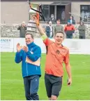  ?? ?? Rothes skipper Bruce Milne holds aloft the cup as boss Ross Jack applauds