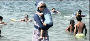  ?? PICTURE: REUTERS ?? A woman wearing a burkini wades in the water on a beach in Marseille, a day after France’s highest administra­tive court suspended a ban on full-body burkini swimsuits.