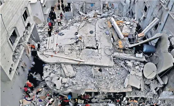  ?? ?? Palestinia­ns inspect the damage after an Israeli air strike on the city of Khan Younis, in the southern Gaza Strip
