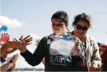  ??  ?? Alexavier Camey brandishes his certificat­e after he returns from his flight during Challenge Air Fly Day on Saturday, when children with autism were given discovery flights around Lake Conroe. Cody Bahn / Staff photograph­er