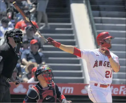  ?? PHOTOS BY MARK J. TERRILL — THE ASSOCIATED PRESS ?? The Angels’ Jared Walsh homers in the fifth inning as Red Sox catcher Christian Vazquez and umpire Adam Beck watch the flight of the ball.