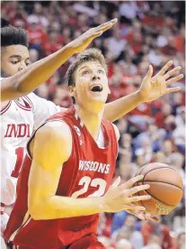  ?? DARRON CUMMINGS/ASSOCIATED PLRESS ?? Wisconsin’s Ethan Happ is defended by Indiana’s Juwan Morgan during Tuesday night’s game. Happ scored 19 points as the Badgers won on the road 75-68.