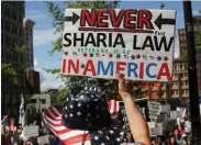  ?? (David Ryder/Reuters) ?? A PROTESTER holds a sign during an anti-Shari’a rally in Seattle on Saturday.