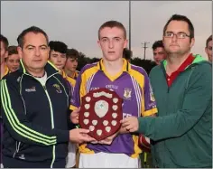  ??  ?? PJ Howlin (Coiste na nOg PRO) and Dean Goodison (People Newspapers) present the Shield to St. Patrick’s captain Joe Cousins.