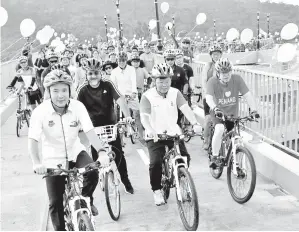  ??  ?? CHOW (dua, kanan) dan bakal Menteri Kewangan Lim Guan Eng (kanan) berbasikal di atas Jambatan lingkaran ‘Spiral Bicycle dan Pedestrian Bridge’ yang diberi nama sebagai Jambatan Harapan berhampira­n pusat membeli belah Queensbay selepas perasmiann­ya pada...