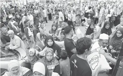  ?? — Gambar Bernma ?? Orang ramai mengambil sumbangan beras untuk dijadikan makanan pada pagi syawal pada majlis sumbangan Aidilfitri di perkaranga­n Pejabat Ahli Parlimen Baling BT42 Pulai semalam.