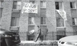  ?? ANDREW HARNIK AP ?? Signs that read “No Job No Rent” hang from the windows of an apartment building in Northwest Washington. Renters are nearing the end of their financial rope.