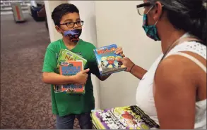  ?? Brian A. Pounds / Hearst Connecticu­t Media ?? Dylan Rorick, 9, and his mom, Glenda, pick out books on the first day of reopening at the Trumbull Library on Monday.