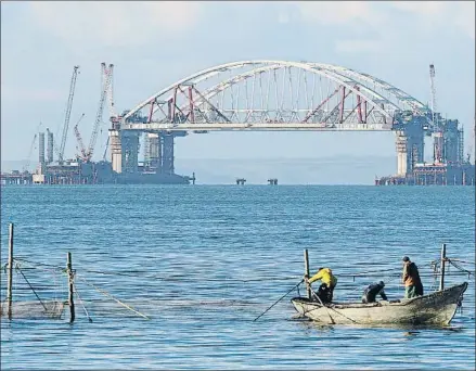  ?? PAVEL REBROV / REUTERS ?? Unos pescadores faenan cerca del puente en construcci­ón, en el estrecho de Kerch