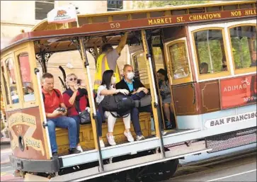  ?? John G. Mabanglo EPA/Shuttersto­ck ?? SOME CABLE CAR riders wear masks Wednesday in San Francisco, which declared a local emergency over the coronaviru­s this week. A new case in Solano County raises concern the virus is spreading within the U.S.