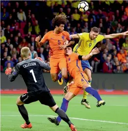  ??  ?? Netherland­s goalkeeper Jasper Cillessen (from left), Nathan Ake, Karim Rekik and Sweden’s Marcus Berg vie for the ball in their World Cup qualifier. —