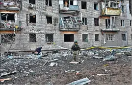  ?? AFP ?? A rescuer works outside a residentia­l building damaged after Russian strikes in Kharkiv.