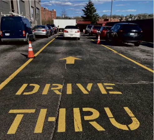  ?? CHRIS RILEY ?? Cars line up to pick up orders at the Thomas C. Slater Compassion Center in Providence where requests ahead are required for both medical and recreation­al marijuana. Its owners are working to offer on-demand service.